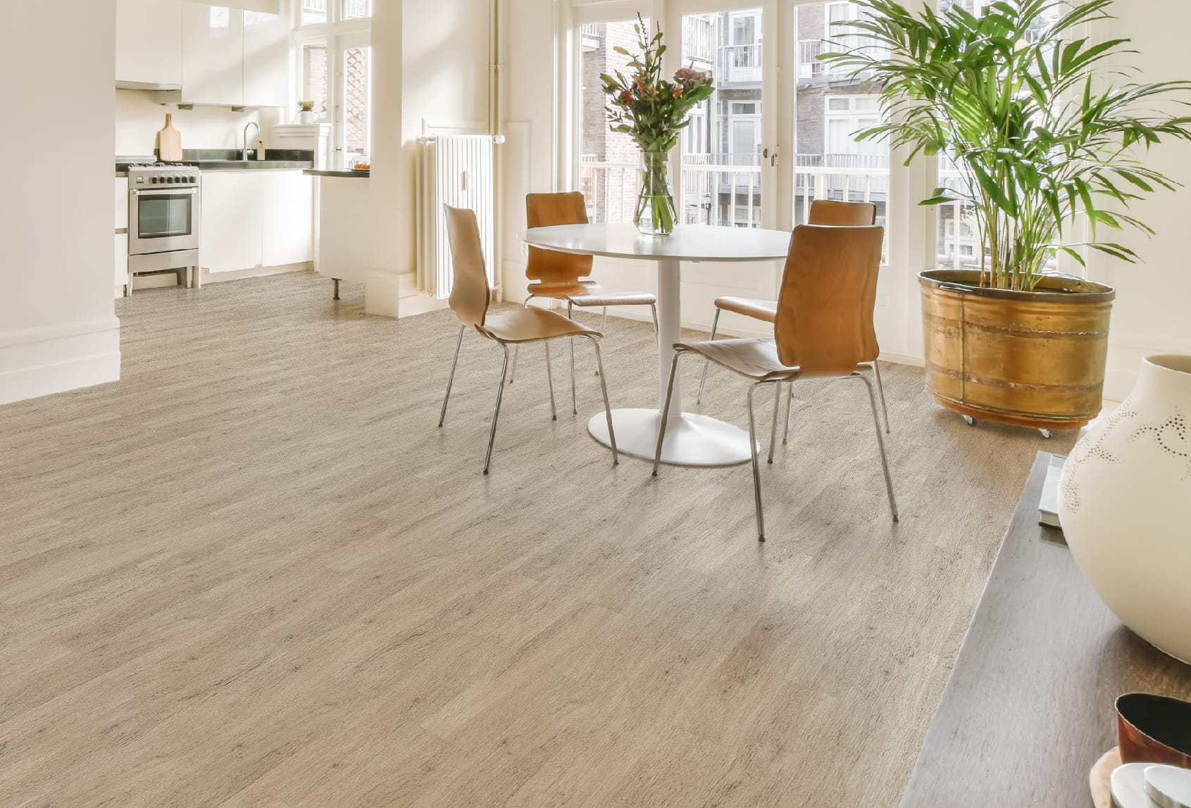 Lantai Vinyl TV 2006 Antique Oak di Ruang Makan dan Dapur Terang - Penerapan lantai vinyl dengan desain Antique Oak yang klasik di ruang makan dan dapur dengan pencahayaan alami, dilengkapi dengan meja makan bundar, kursi kayu, dan tanaman hias, menciptakan suasana hangat dan vintage di dalam rumah.